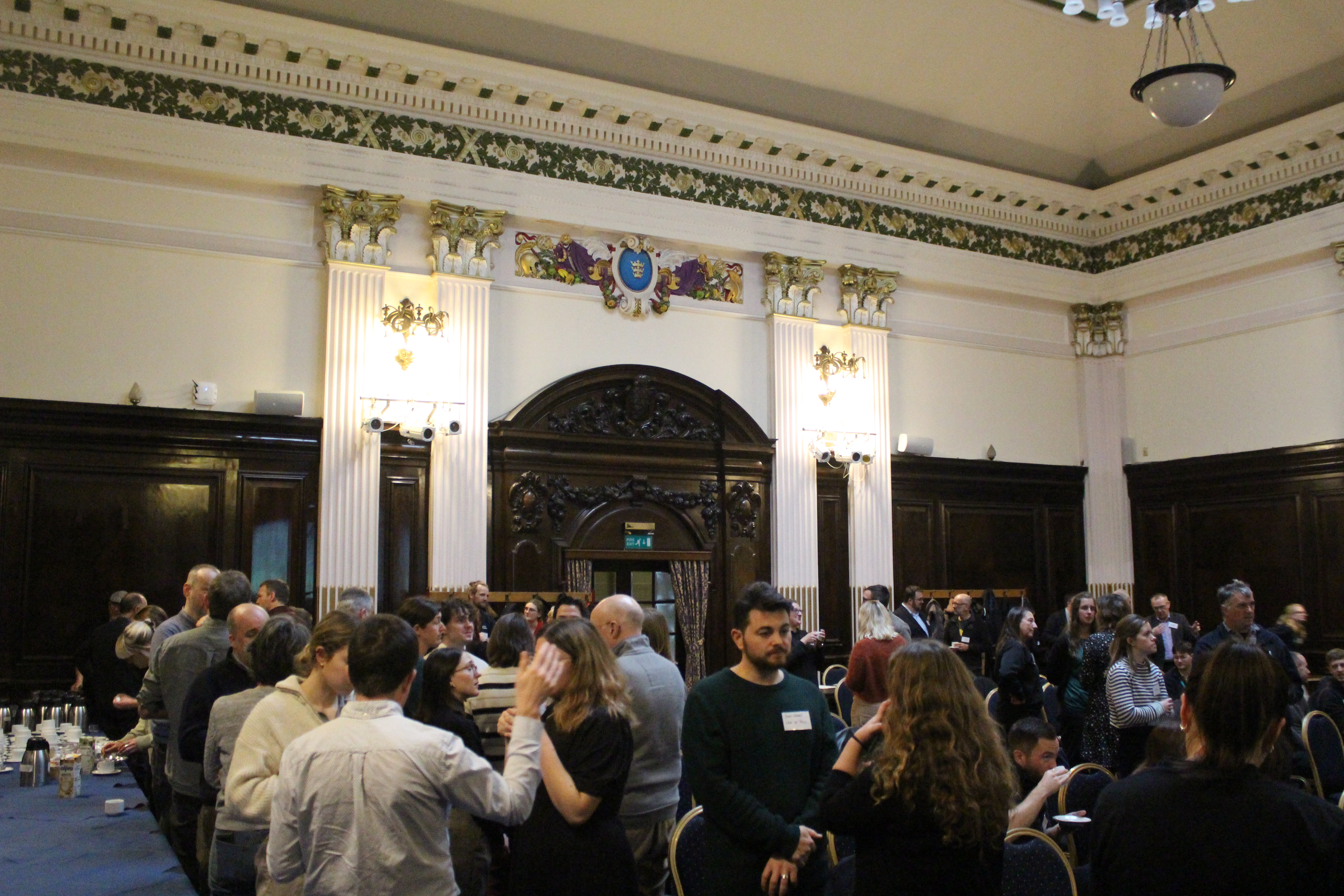 A room filled with people that are standing and talking.